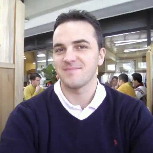 Mi dispiace, non so chi sia la persona nella foto. Persona che sorride in un ambiente interno, con altre persone sullo sfondo.