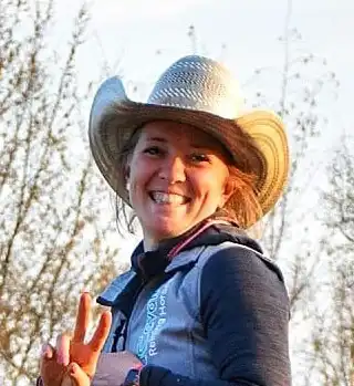 Donna sorridente con cappello da cowboy all'aperto.