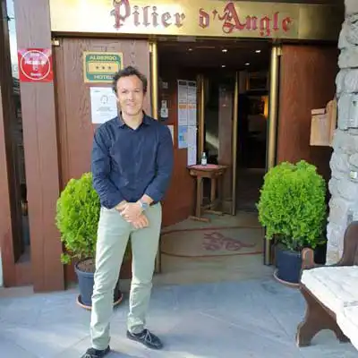 Uomo in piedi davanti all'ingresso dell'hotel Pilier d'Angle.